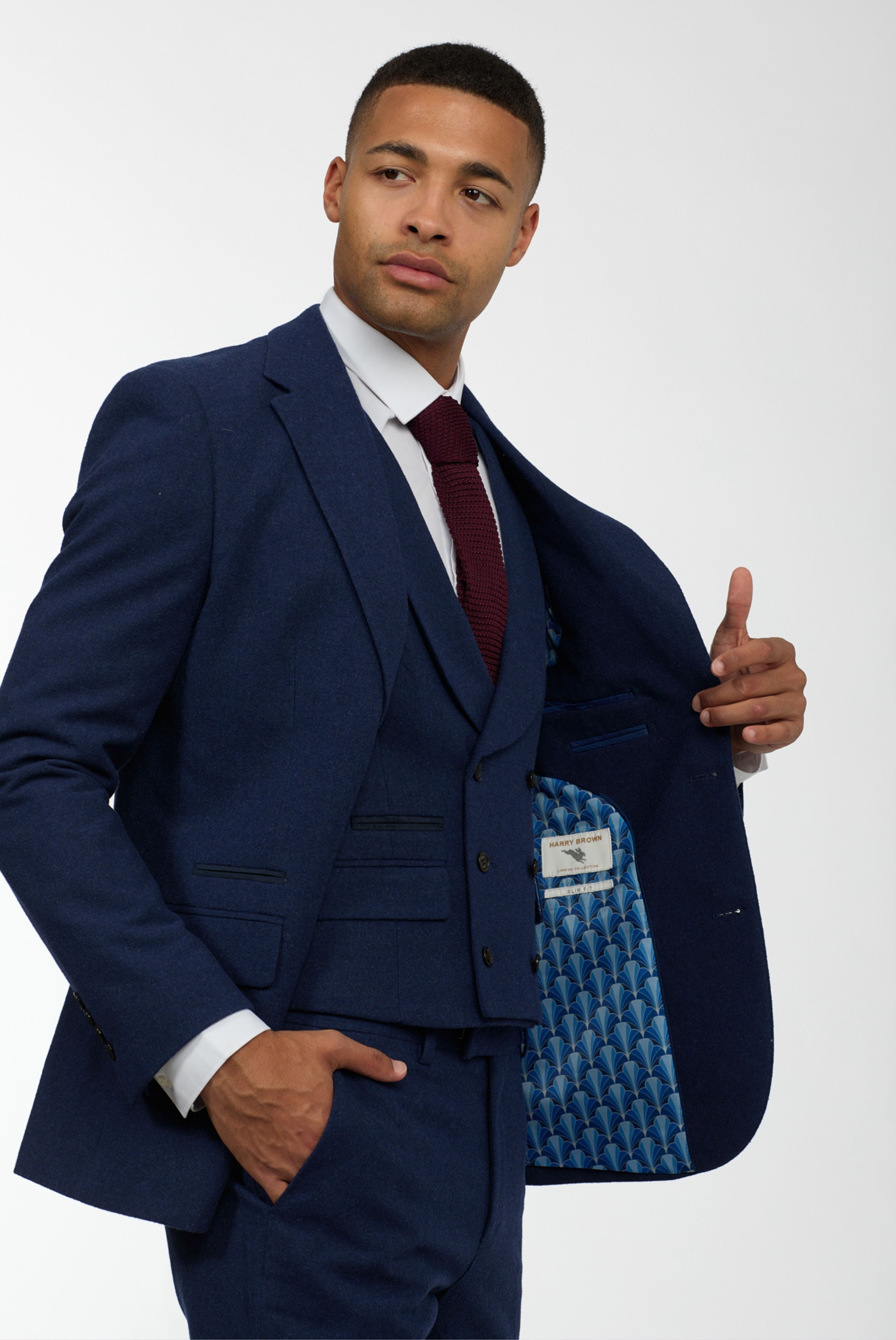 Elevate your style with a modern London twist in this wool tweed three-piece slim-fit suit in navy.